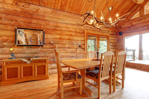 Log home dining room interior with custom furniture.